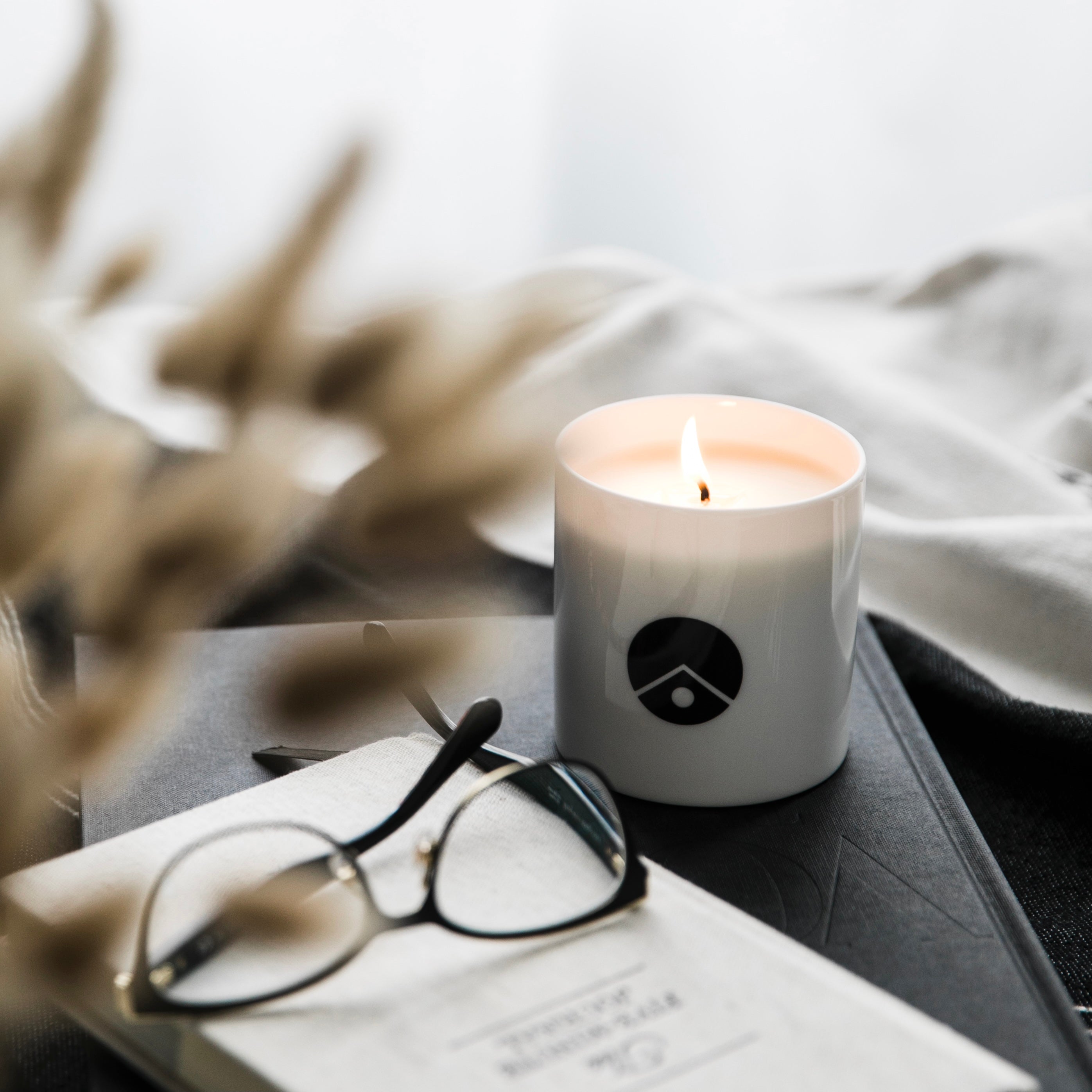 white burning candle on the table with glasses